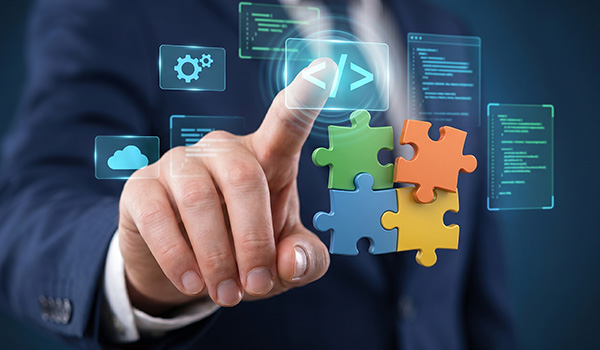 A person in a business suit points at virtual code symbols and icons, with colorful 3D puzzle pieces in the foreground, representing software development and integration. A person in a business suit points at virtual code symbols and icons, with colorful 3D puzzle pieces in the foreground, representing software development and integration.